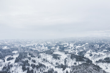 Fototapeta na wymiar ドローン撮影：真っ白な雪に覆われた山