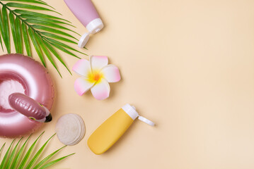 Summer composition with sunblock lotion bottles, palm leaf, sea shells and plumeria on pink background copy space Summer vacation and skin care concept spf uv-protect cosmetics