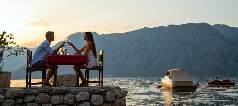 Couple is having a private event dinner on a tropical beach during sunset time