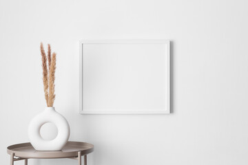 White frame mockup on the wall with a pampas decoration.