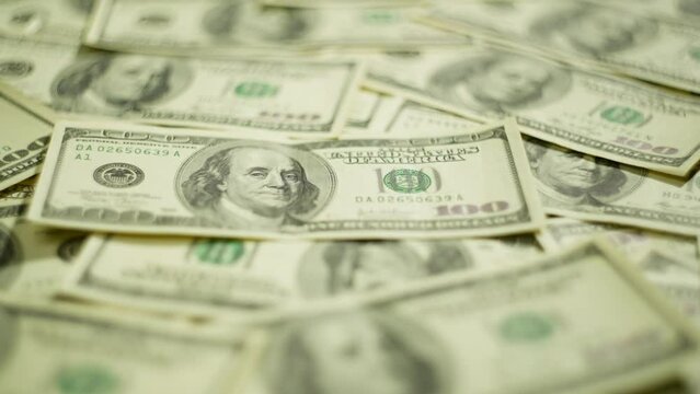 Background video on which one hundred dollar banknotes are spread out. Cash, business, cash settlement, economy. High quality 4k footage