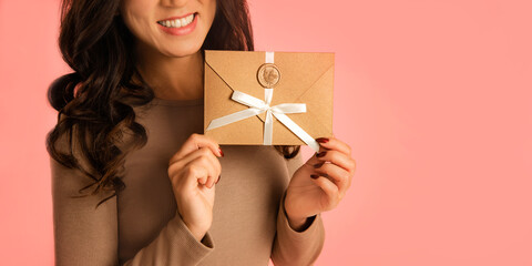 stylish woman enjoy Gift Certificate, festive mood in holidays on pink background