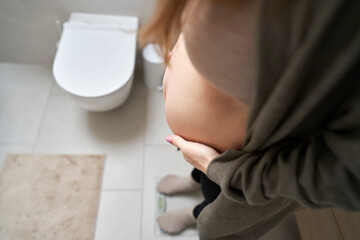 Pregnant woman standing on bathroom scale