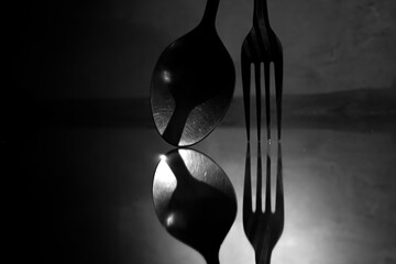 shadow or reflection of a spoon and fork standing on the floor