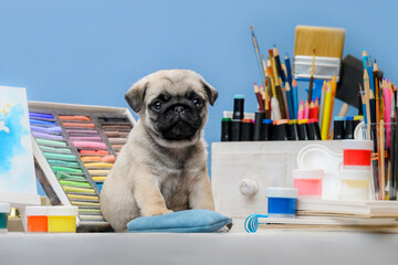 pug puppy with art supplies: easel, pastels and pencils