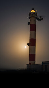 Abades lighthouse with the sea and the full moon