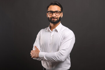 Headshot of intelligent professional Indian businessman wearing formal wear and eyeglasses looking...