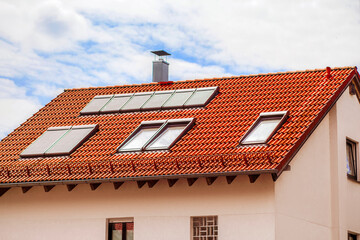 Skylights Roof Windows Dormers with Shutters Outdoor on Red Tiles Roof of Private House on Sky Background.