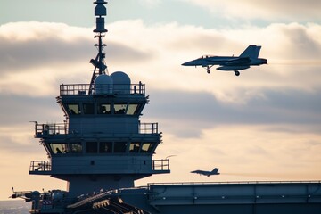 control tower on carrier with jet taking off in the background
