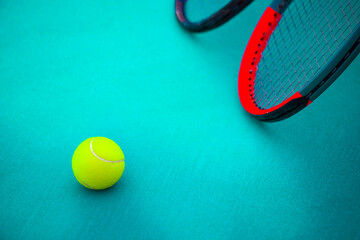 tennis racket and ball on a tennis court on a bright sunny day	