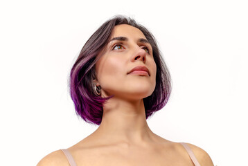 Fototapeta premium Portrait of a cute woman with purple hair. Looking up. Bare shoulders. White background, isolated.