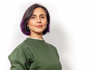 Close-up portrait of Caucasian woman with dark purple hair in natural makeup and green sweater.