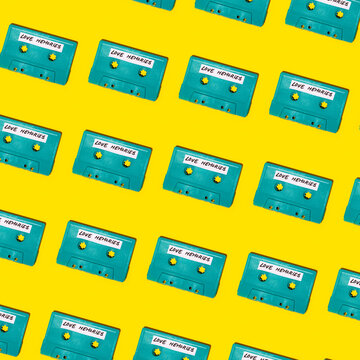 Collection of retro cassettes arranged on yellow surface
