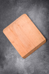 Empty wooden cutting board on a light texture background