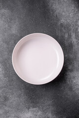 Empty round ceramic plate on a light texture background