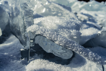 The sun's rays are refracted in crystal clear pieces of ice. winter landscape. A piece of ice and...