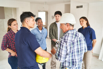 Architect supervisioning team group of construction workers onsite