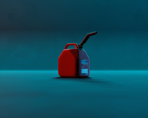 Red plastic jerry can against blue green background. Low key studio shot.