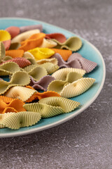 Colorful pasta background. Top view of five colors pasta shells .Heap of colorful spiral pasta,macaroni texture.