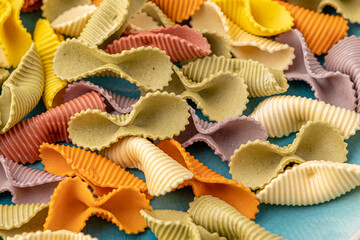 Colorful pasta background. Top view of five colors pasta shells .Heap of colorful spiral pasta,macaroni texture.