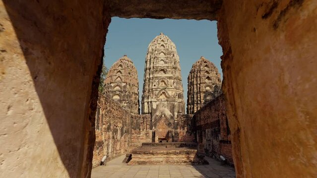 Wat Si Sawai at Sukhothai Historical Park. Three prangs (pagodas) are surrounded by a laterite wall. Inside the wall, the viharn in the west, built of laterite in the Lop Buri or Hindu-style