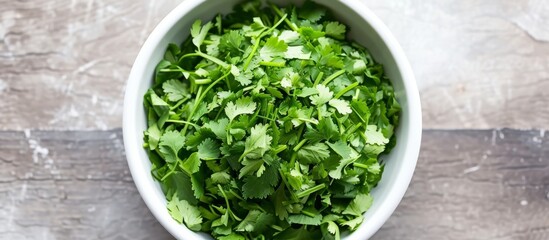 Freshly chopped coriander lies on top of a white bowl.