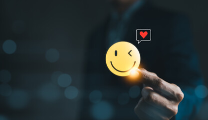 Mental Health Day concept. Hand holding a smiley face icon that depicts happy and giving a heart of love in the message box. positive thinking, Take care of your mental health, Customer satisfaction,