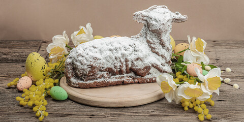 Easter lamb cake with traditional spring decor. Baked sweet dessert with icing. Festive background