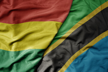 big waving national colorful flag of tanzania and national flag of bolivia .