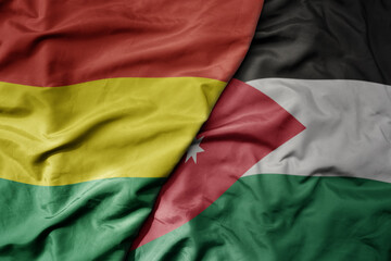 big waving national colorful flag of jordan and national flag of bolivia .