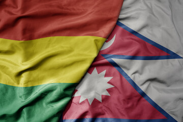 big waving national colorful flag of nepal and national flag of bolivia .