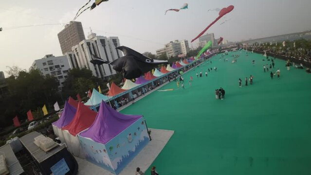 This captivating aerial footage showcases the vibrant spectacle of the International Kite Festival in Ahmedabad, India. The sky is adorned with a myriad of colorful kites of various shapes and sizes