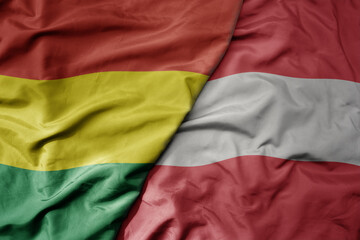 big waving national colorful flag of austria and national flag of bolivia .