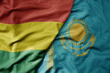 big waving national colorful flag of kazakhstan and national flag of bolivia .