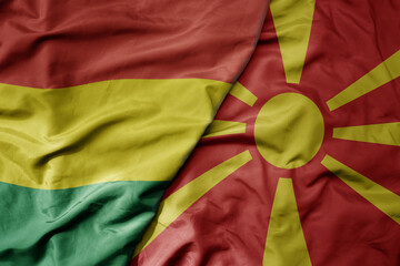 big waving national colorful flag of macedonia and national flag of bolivia .
