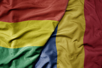 big waving national colorful flag of romania and national flag of bolivia .