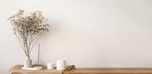 A Wooden Table With A Vase Of Dried Flowers And Candles On It