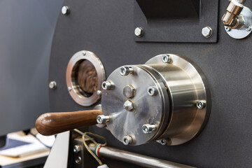Industrial coffee roaster close-up photo, roasting coffee seeds are inside