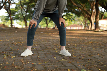 Obraz premium Cropped of asian woman tired, holding her legs, exhausted, taking a rest after running hard