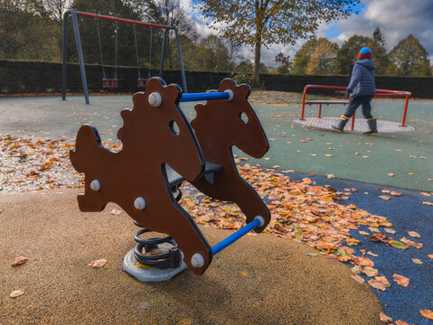 brown, horse-shaped spring rider in a playground during autumn.