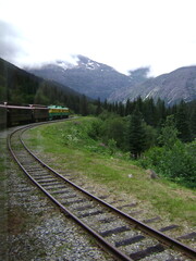 Fototapeta premium train on railroad in the mountains going around curve