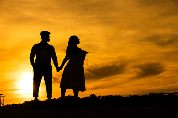 silhouettes Man and woman against the backdrop of sunset, lovers, intimacy