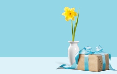 Gift box with fresh flowers in vase.
