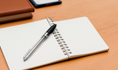 a notebook with a pen on the table