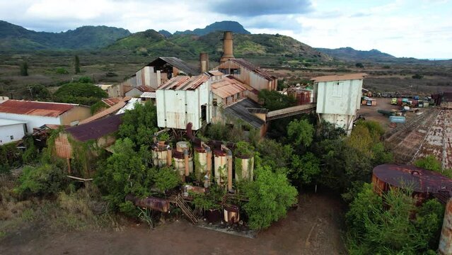 zoom of koloa sugar mill with mountains in background, drone aerial