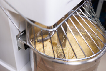 A bread mixer in a bakery, kneading dough for baguettes and rolls.