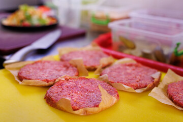 Cutlets of raw meat for a burger on the kitchen table of the restaurant before roasting.