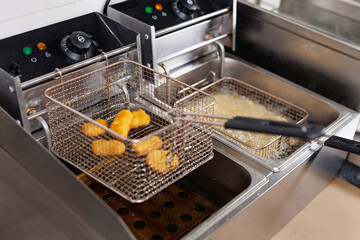 Close up image of cooking chicken nugget tempura in deep fry on kitchen.