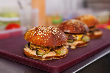 Juicy burgers with cheese sauce in the kitchen at a fast food restaurant are ready to serve.