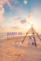 Fototapeta premium Love couple proposal romantic proposal on paradise beach in island Maldives. Panoramic sunset of Marry Me sign sandy beach background. Romance colorful sky sea. Marriage honeymoon tropical destination